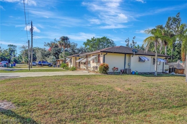 view of property exterior with central AC and a yard