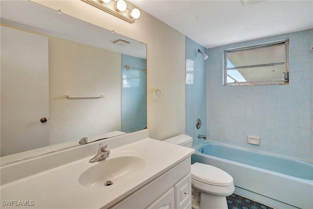 full bathroom featuring vanity, tiled shower / bath combo, and toilet