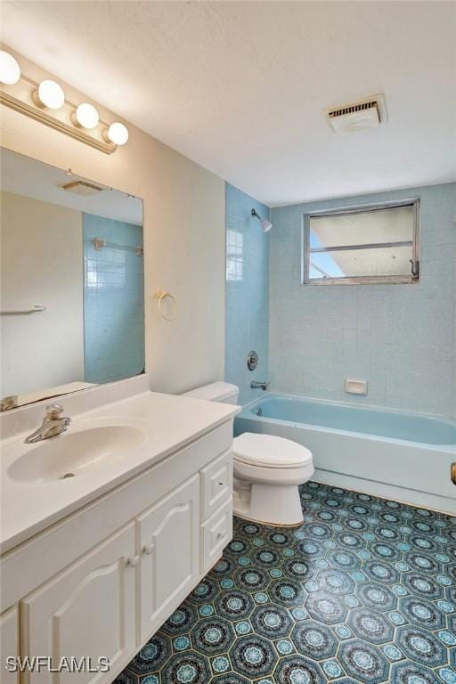 full bathroom featuring tile patterned floors, vanity, toilet, and tiled shower / bath