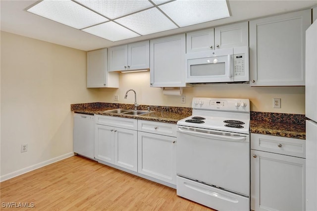 kitchen featuring sink, white cabinets, and white appliances