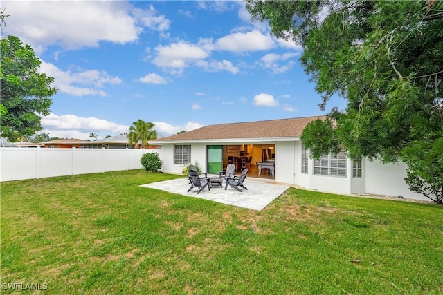 rear view of house with a yard and a patio area