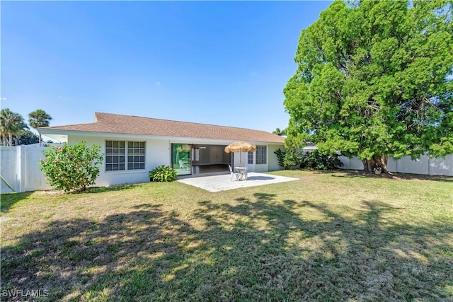 rear view of house featuring a patio area, a fenced backyard, stucco siding, and a lawn