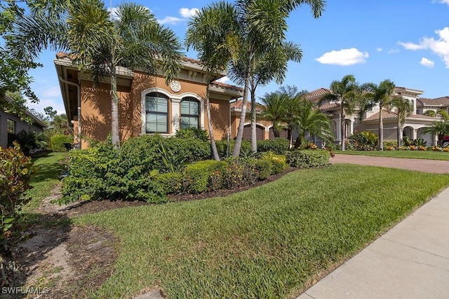 mediterranean / spanish-style home with a front yard