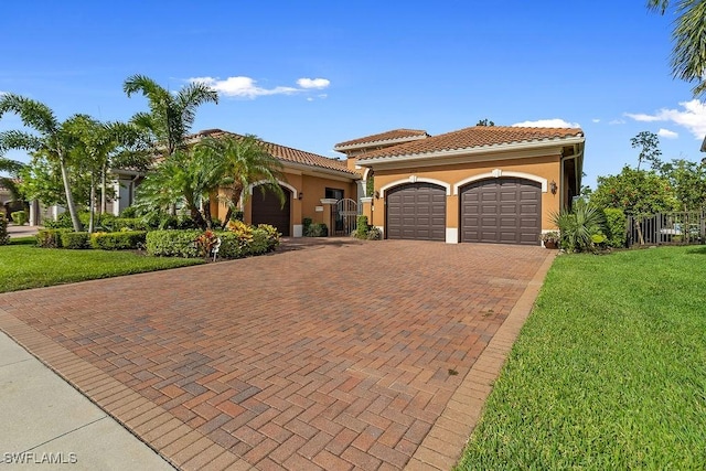 mediterranean / spanish-style home featuring a front yard and a garage