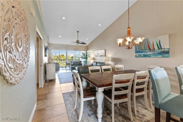 tiled dining space featuring ceiling fan with notable chandelier and high vaulted ceiling