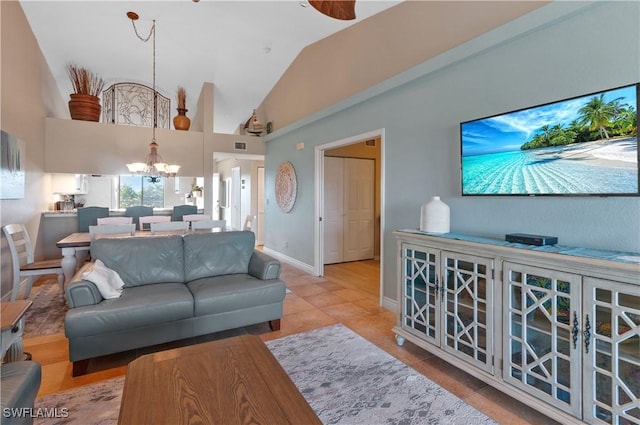 tiled living room with vaulted ceiling and an inviting chandelier