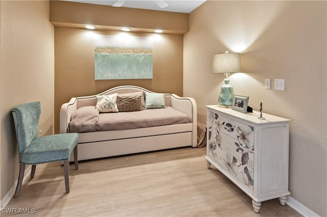 living area featuring light wood-type flooring and ceiling fan