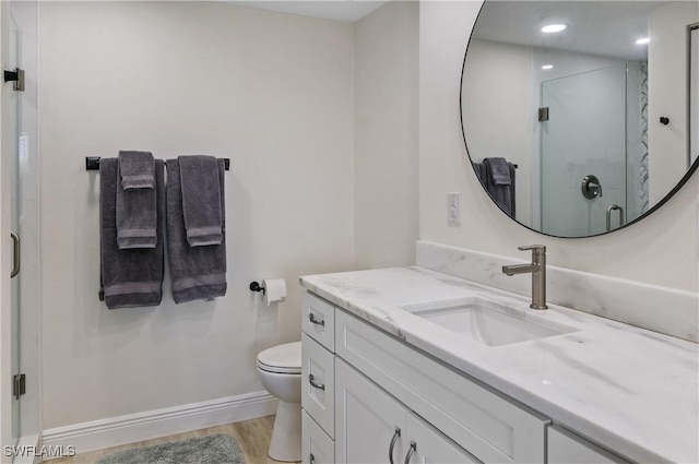 bathroom featuring hardwood / wood-style flooring, vanity, toilet, and walk in shower