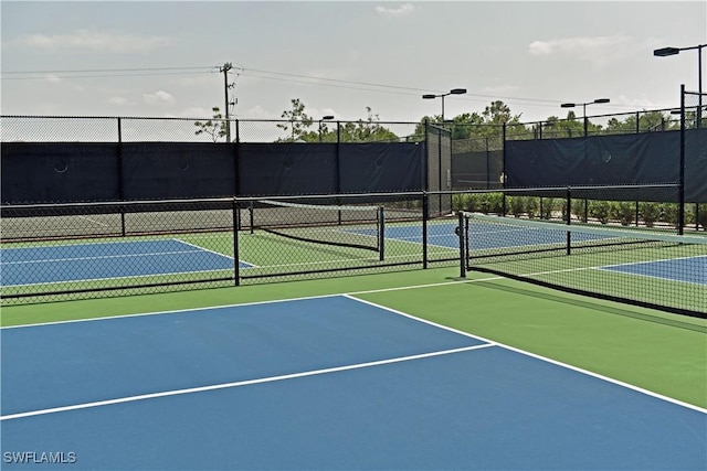 view of tennis court featuring basketball hoop