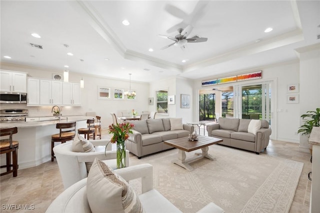 living room featuring a raised ceiling, ceiling fan, crown molding, and french doors