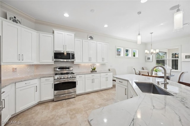 kitchen with stainless steel appliances, white cabinetry, hanging light fixtures, and sink