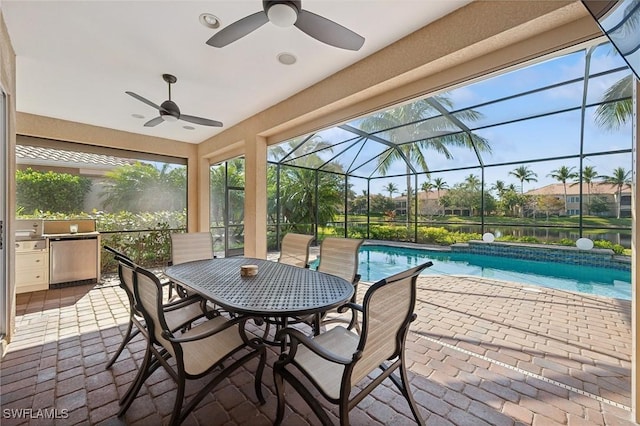 view of swimming pool with a lanai, ceiling fan, a patio, and exterior kitchen