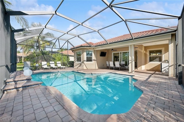 view of pool featuring ceiling fan, a lanai, and a patio