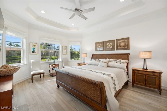 bedroom featuring ceiling fan, light hardwood / wood-style floors, a raised ceiling, and ornamental molding