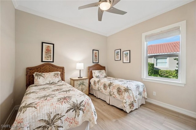 bedroom featuring light hardwood / wood-style flooring, ceiling fan, and ornamental molding