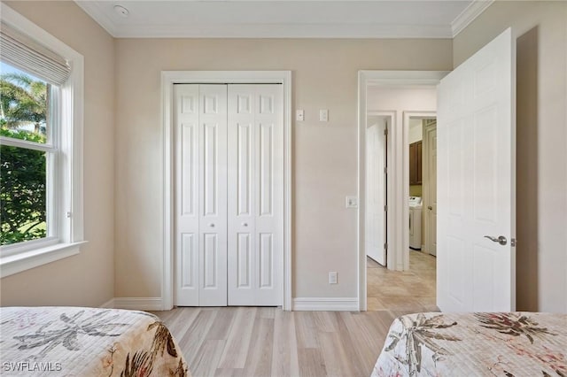 bedroom featuring multiple windows, light hardwood / wood-style floors, a closet, and ornamental molding