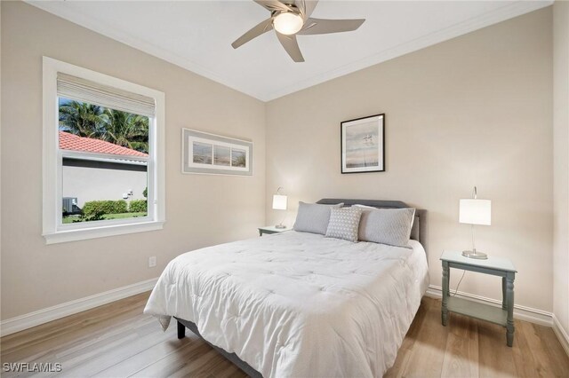 bedroom with ceiling fan, hardwood / wood-style floors, and ornamental molding