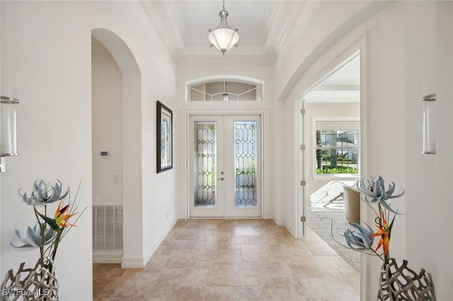 entrance foyer with crown molding and french doors