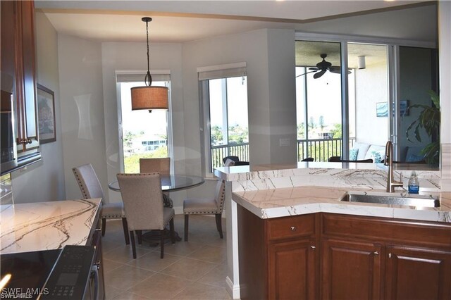 kitchen with decorative light fixtures, ceiling fan, light tile patterned floors, and sink