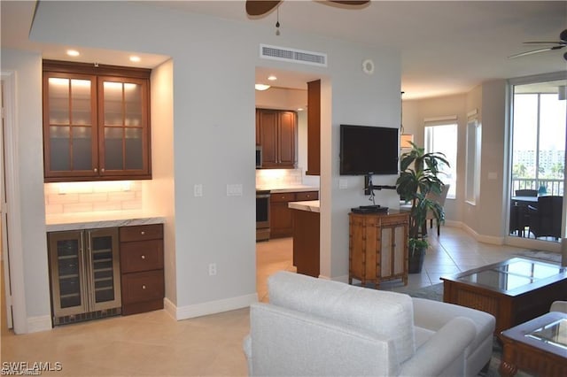 living room with ceiling fan, light tile patterned floors, and beverage cooler