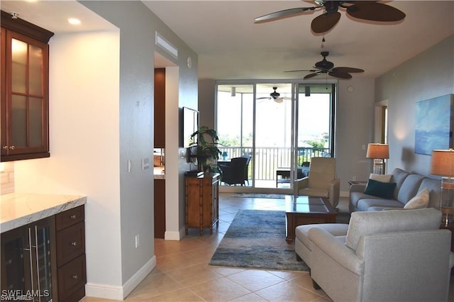 living room with light tile patterned floors, wine cooler, and ceiling fan