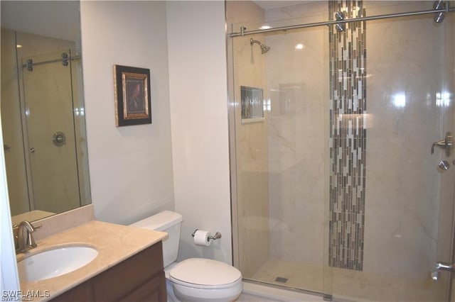 bathroom with vanity, a shower with shower door, and toilet