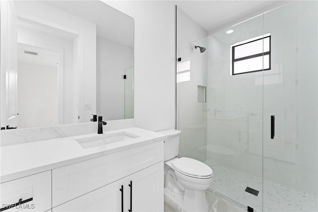 bathroom with vanity, toilet, and a shower with shower door