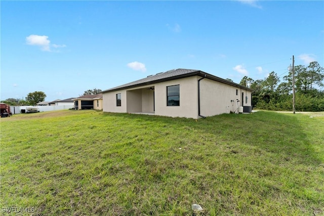 exterior space featuring central AC and a yard