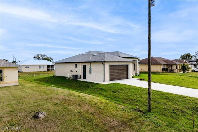 view of front of property with cooling unit, a front yard, and a garage