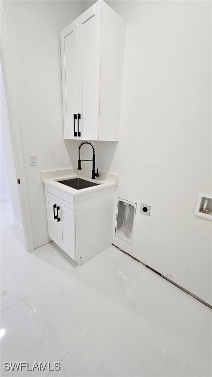 clothes washing area featuring washer hookup, electric dryer hookup, cabinets, and sink