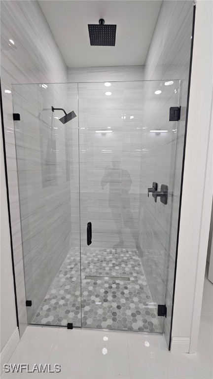 bathroom with tile patterned floors and a shower with door