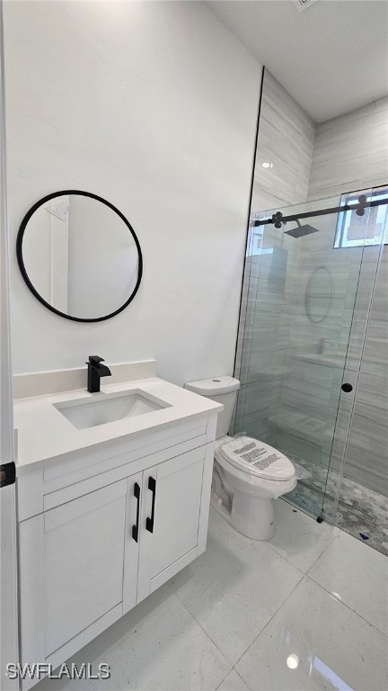 bathroom with vanity, a shower with shower door, and toilet