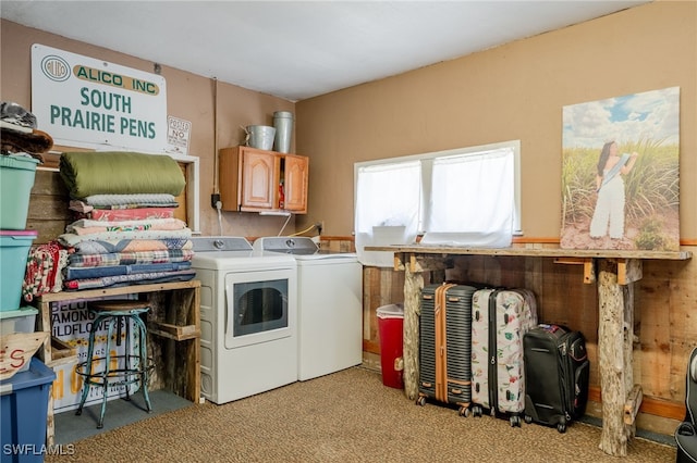 clothes washing area featuring separate washer and dryer, light carpet, and cabinets