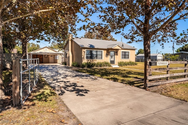 view of front of house with a front yard, a garage, and an outdoor structure