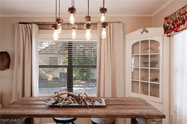 dining area featuring crown molding, plenty of natural light, and a textured ceiling