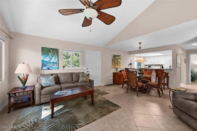 tiled living room with ceiling fan and high vaulted ceiling