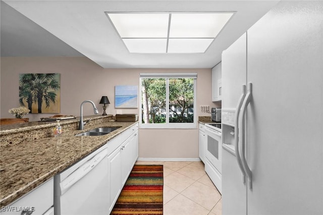 kitchen featuring white cabinetry, sink, dark stone counters, and white appliances