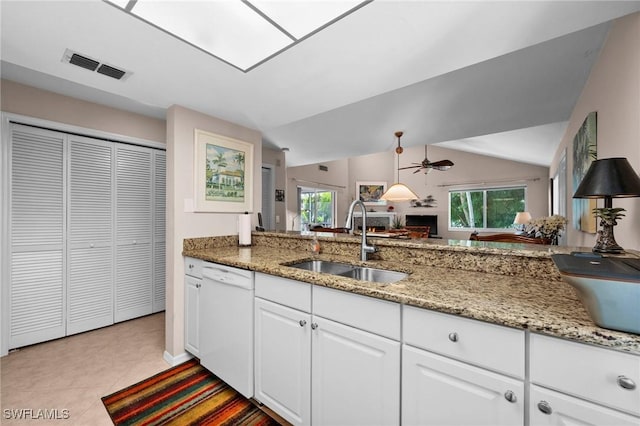 kitchen with dishwasher, sink, white cabinets, lofted ceiling, and light tile patterned floors