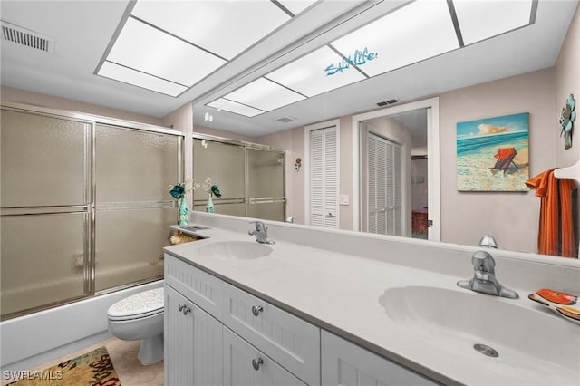 full bathroom with tile patterned floors, vanity, toilet, and enclosed tub / shower combo