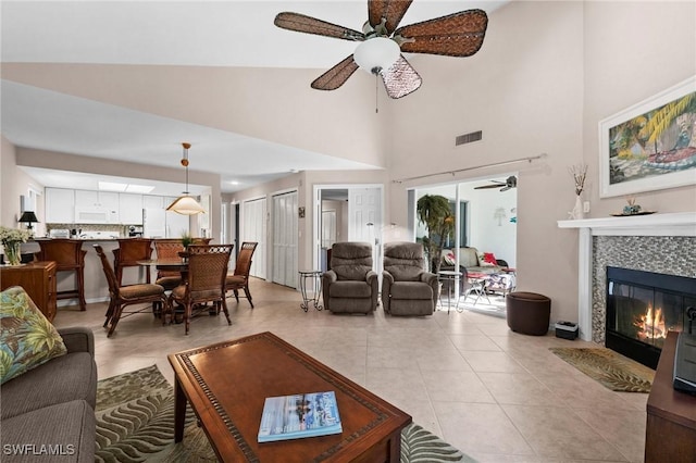 tiled living room featuring a tile fireplace and ceiling fan