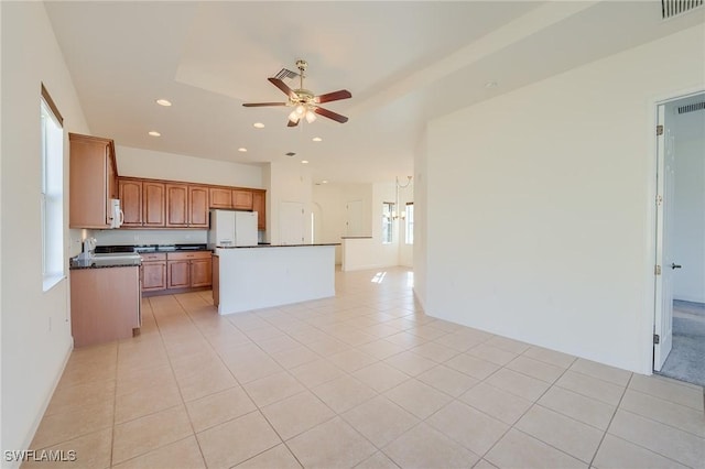 kitchen with ceiling fan, a kitchen island, white appliances, and light tile patterned floors