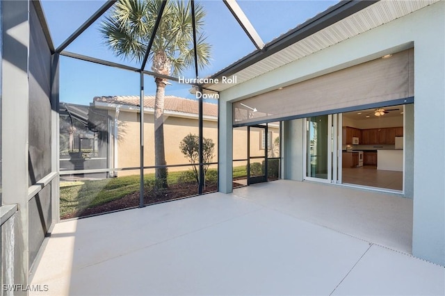 unfurnished sunroom featuring ceiling fan