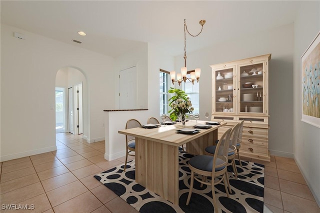 dining space with a chandelier and light tile patterned flooring