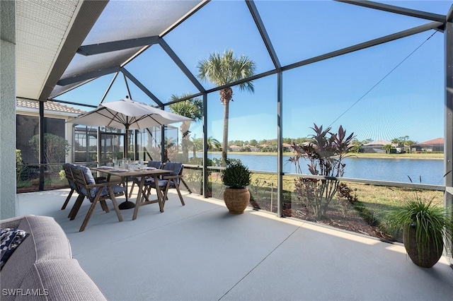 view of patio featuring a water view and glass enclosure