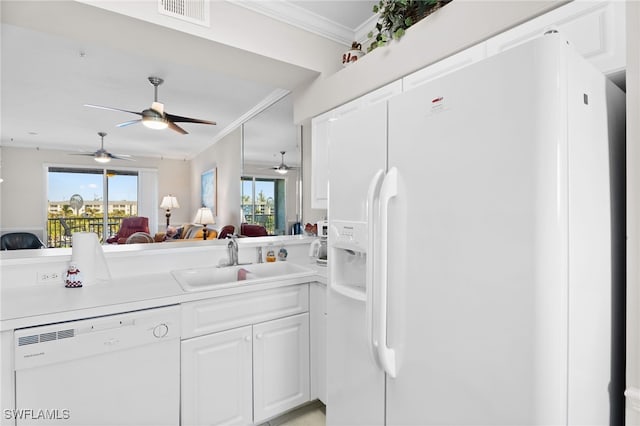 kitchen with a sink, light countertops, ceiling fan, white appliances, and crown molding