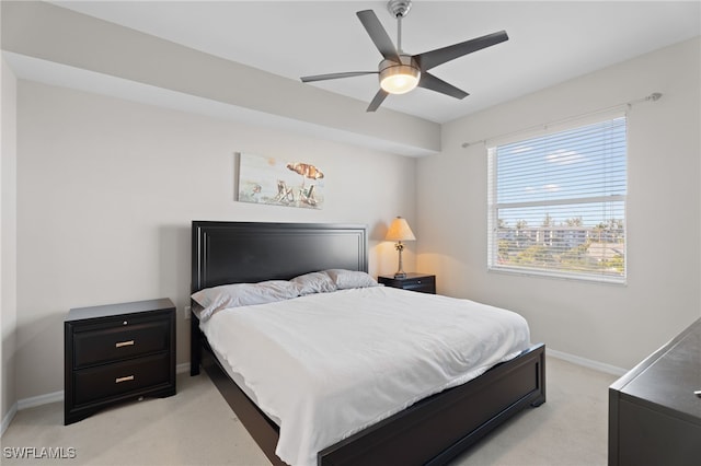 bedroom with light carpet, baseboards, and ceiling fan