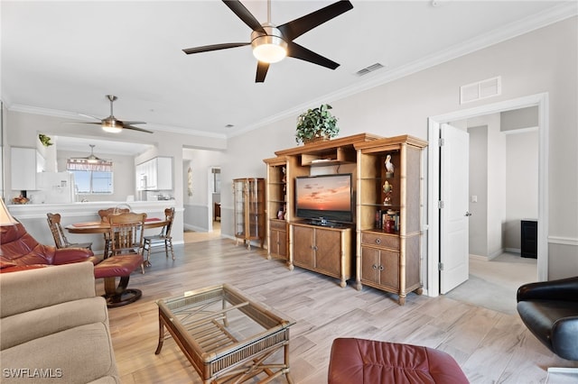 living room featuring ceiling fan, light wood-type flooring, and crown molding