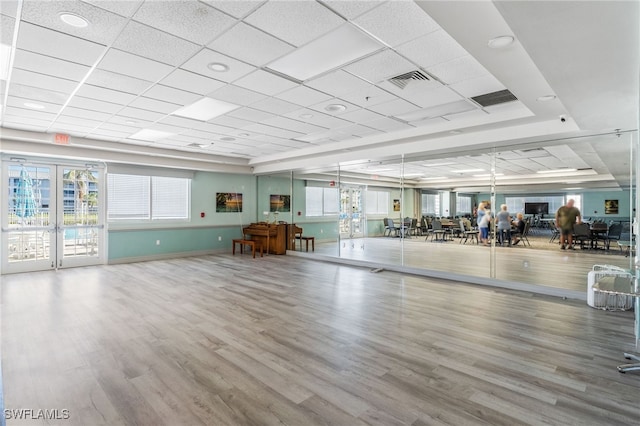 exercise room featuring hardwood / wood-style floors and a drop ceiling