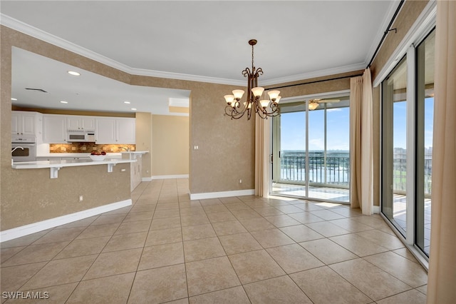 interior space featuring light tile patterned floors, a notable chandelier, crown molding, and baseboards