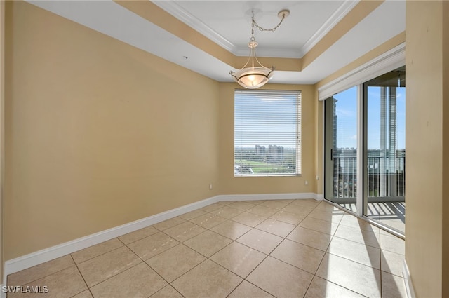 unfurnished room with light tile patterned flooring, baseboards, crown molding, and a tray ceiling